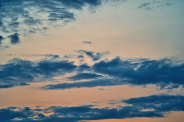Western sky at sunset. A relaxing scene of day's end with gentle clouds stretching across the horizon. Shades of blue and orange