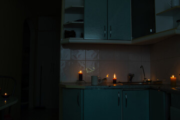 Kitchen by candlelight during power outage - coziness in the dark, candles on the countertop,...