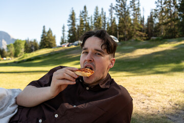 Man eating pizza outdoors