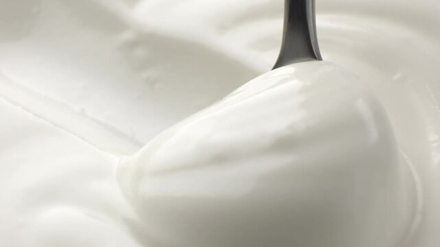 Close-up spoon scooping natural yogurt from package, concept video for commercial
