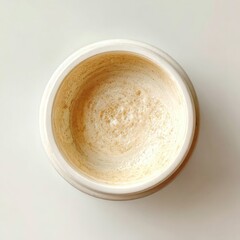 Nearly-empty, round, white jar of light-beige, grainy cream; residue visible on bottom and sides