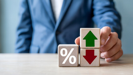 Rising and falling interest rates are represented by wooden blocks, highlighting economic fluctuations, market trends, and financial uncertainty within the global economy.