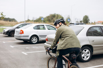 Fototapeta premium Young bearded man in helmet and casual clothes riding bicycle to work.