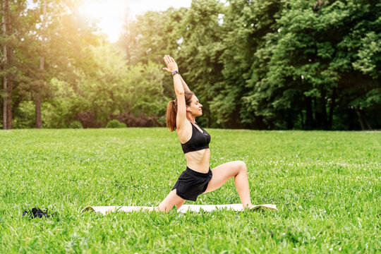Fit woman doing yoga exercise in urban green park in summer - Powered by Adobe