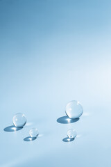 Glass balls arranged on a gradient blue background, creating a modern podium for luxury skincare product displays and high-end cosmetic presentations