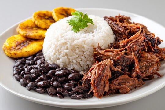 Delicious Pabellon Criollo plate featuring rice, black beans, pulled beef, and plantains showcased on a white background
