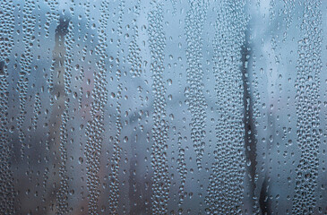 Double glazed window condensation causes by excessive moisture in the house in the cold season. PVC double glazed window with water drops due to humidity in the cold weather. Background and texture