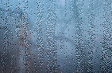 Double glazed window condensation causes by excessive moisture in the house in the cold season. PVC double glazed window with water drops due to humidity in the cold weather. Background and texture