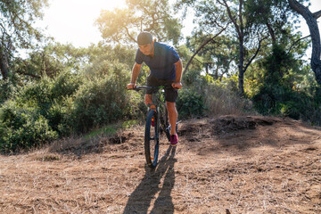 Mountain biker riding bike in green forest