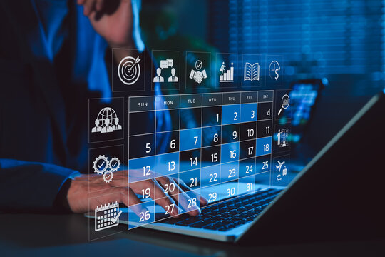 Time management and calendar planning concept. A person using laptop with digital monthly calendar, representing time management, event planning, appointment, agenda meeting, and schedule organization