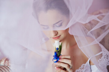 A woman wearing a veil and holding a flower in her hand