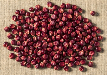 Close-Up Flatlay of Purple Corn Scattered on Linen Fabric