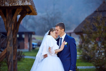 A bride and groom are standing in front of a building