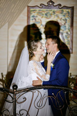 A bride and groom are embracing each other in front of a painting