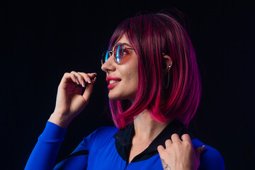 Obraz premium Stylish futuristic woman in blue bodysuit and sunglasses