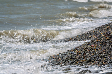 Sea water splashing over the stones on the beach