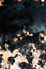 Close up of heavy black rust on a brass base of a kitchen sauce pan abstract background