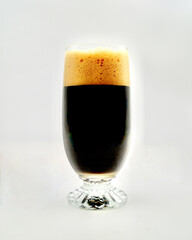 An oatmeal stout in a glass isolated against a white background.