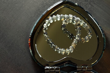 A beautiful labradorite bead bracelet reflected in a heart-shaped mirror, symbolizing inner beauty,...