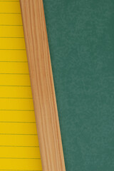 Green chalkboard with yellow ruled loose leaf notebook paper background