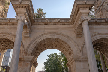 Obraz premium The Arch of ancient times. The famous gate, built in honor of the ancient Roman emperor. The Arc de Triomphe in the Kaleici area. Hadrian's Gate in Antalya. The arch is decorated with carved patterns.