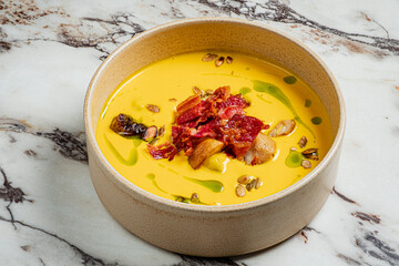This tasty bowl has creamy soup topped with crispy bacon and seeds, ideal for a hearty meal