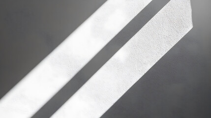 Light and shadow on textured plaster wall creating abstract minimalist background with diagonal geometric composition