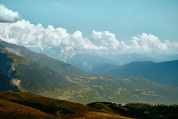 Fototapeta premium Mountain ranges on a sunny day at Georgia. Sky with clouds adn hills