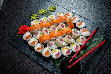 An artfully arranged sushi platter features a variety of rolls and colorful garnishes