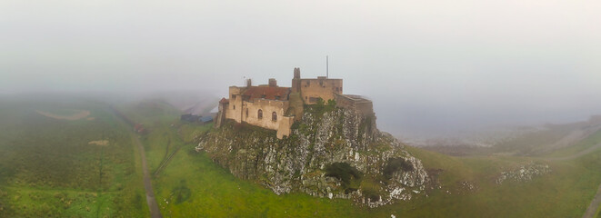 Misty Morning Panorama of Lindisfarne Castle, Holy Island &ndash; Atmospheric Drone Shot