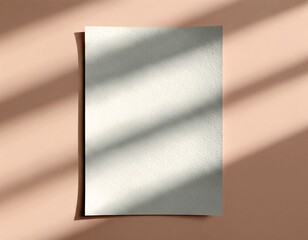 A textured, blank paper mockup on a beige background with beautiful shadow overlays from a window, perfect for showcasing stationery or artwork designs.