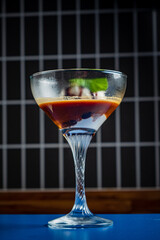 A refreshing cocktail mixes rich flavors and colorful layers, garnished with mint leaves