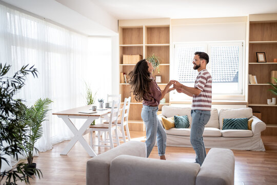Happy couple dancing and enjoying their new home together