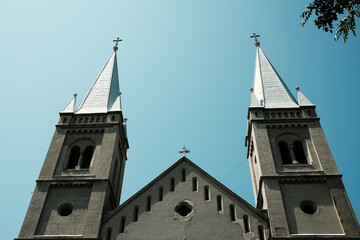 A dramatic close-up of the symmetrical twin spires of the Subotica church, captured against a deep...