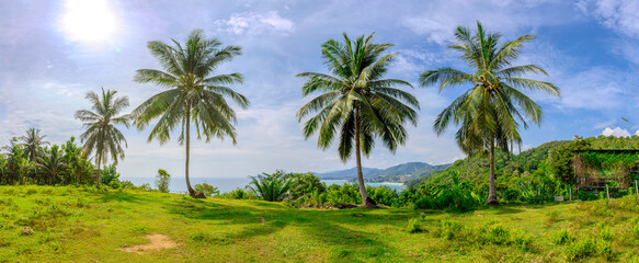 Obraz premium Views through lush green trees and palms over looking Kata and Kata Noi on the beautiful island of phuket in Thailand with lush green mountains and turquoise blue waters of the Andaman Sea