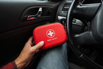 A responsible individual keeps a wellstocked red first aid kit in their vehicle, highlighting the...