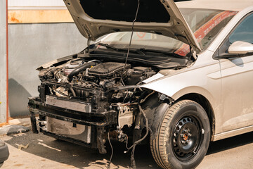 The car with the front hood open is waiting for repair