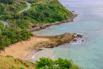 Ya Nui Beach in Phuket Thailand, turquoise blue waters, lush green mountains colourful skies. Phuket is a tropical island many palms