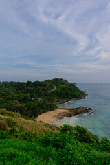 Ya Nui Beach in Phuket Thailand, turquoise blue waters, lush green mountains colourful skies. Phuket is a tropical island many palms