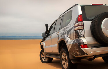 A powerful gray 4x4 SUV stands alone in the vast sandy terrain of the Namib Desert, ready for off-road travel, exploration, and endurance across one of Africa’s wildest landscapes. 