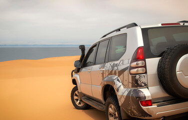 A powerful gray 4x4 SUV stands alone in the vast sandy terrain of the Namib Desert, ready for off-road travel, exploration, and endurance across one of Africa’s wildest landscapes. 