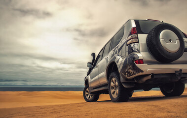 A powerful gray 4x4 SUV stands alone in the vast sandy terrain of the Namib Desert, ready for off-road travel, exploration, and endurance across one of Africa’s wildest landscapes. 