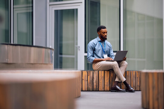 Black businessman working on laptop. - Powered by Adobe