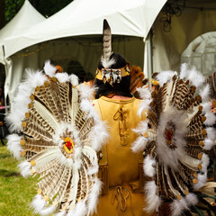 Back view of Huron-Wendat native woman in ceremonial regalia for the annual Pow Wow, including a...