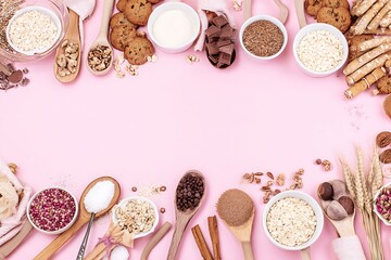Baking ingredients on pink background overhead