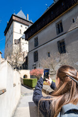 Mujer turista recorriendo el Castilo de Karlštejn en un día soleado y sin gente. Fotografía vertical