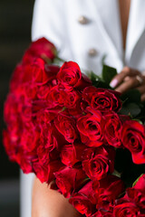 beautiful mulatto woman with a large bouquet of scarlet roses
