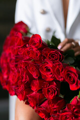 beautiful mulatto woman with a large bouquet of scarlet roses