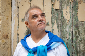 Gray-haired man between 50 and 60 years old, looking skyward. An adult with a worried expression.