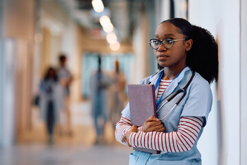 Pensive black medical student in hallway at university.